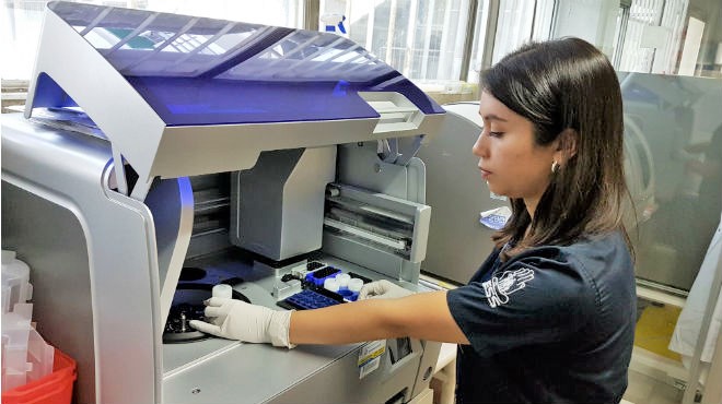 Gabriela Peralta, analista molecular, mientras usa el Robot Extractor.